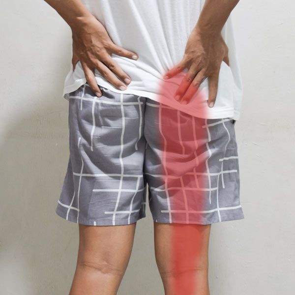 man with sciatic pain running down his right leg