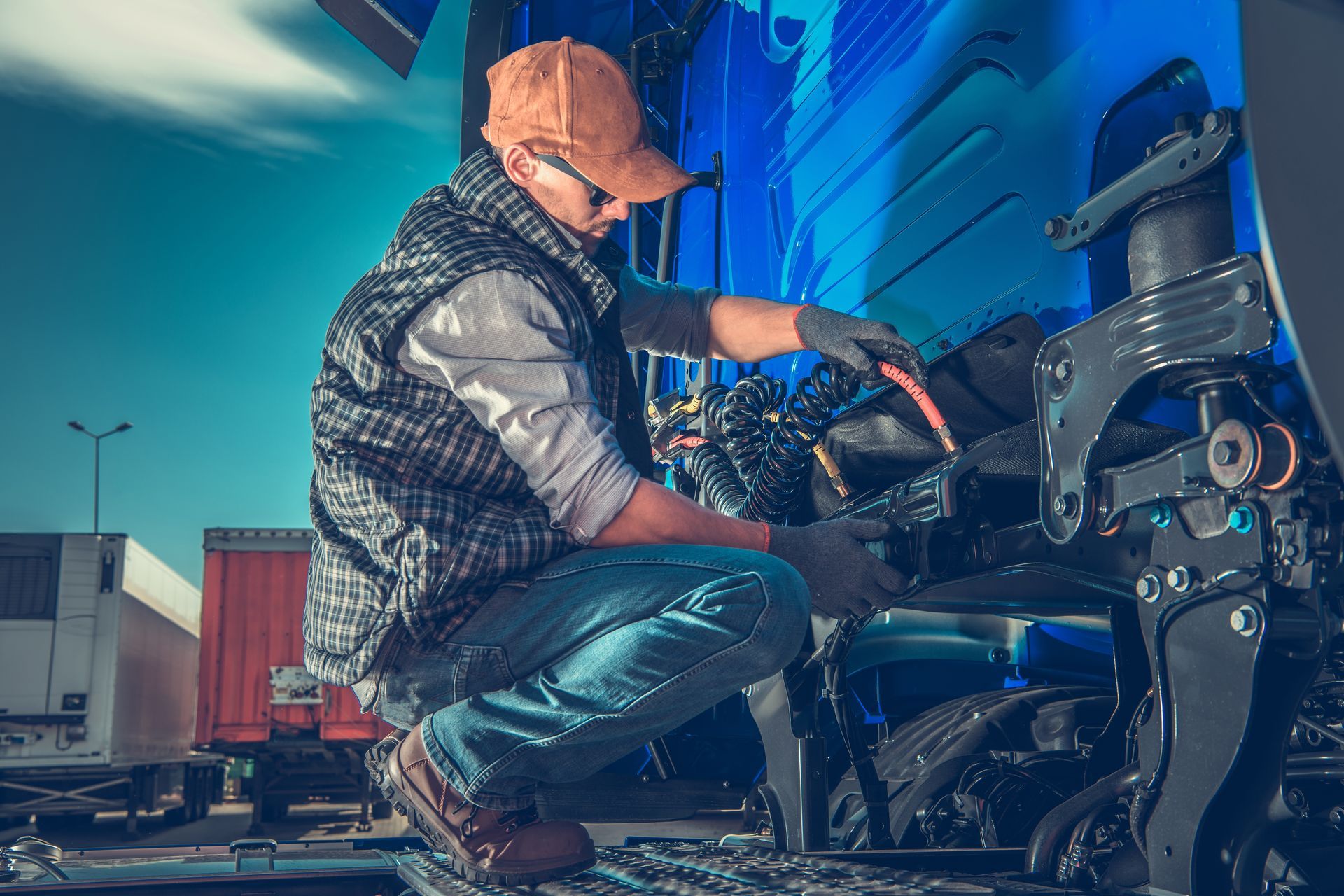 A man is working on the engine of a truck.