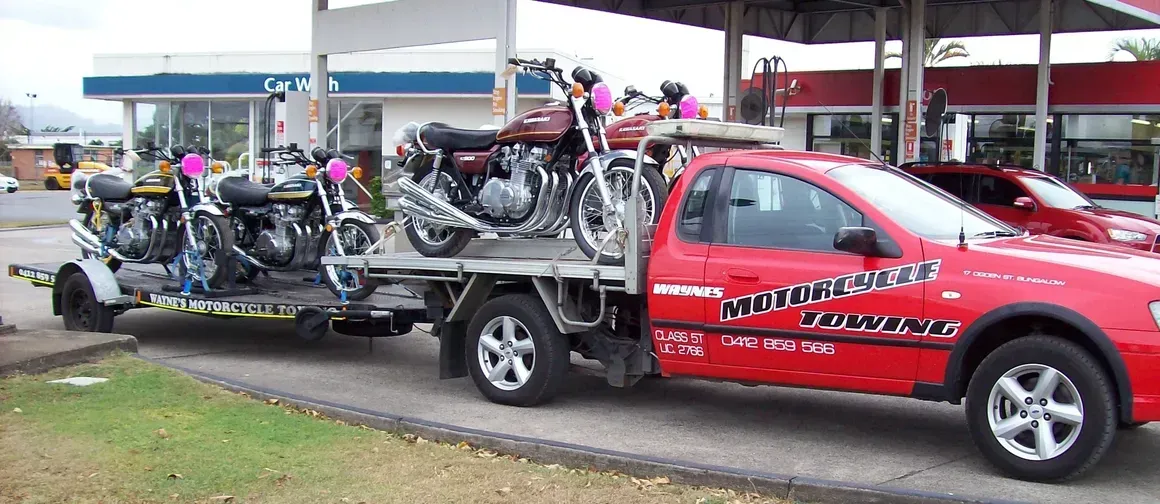 A Red Truck Is Towing Two Motorcycles On A Trailer  — Motorcycle Transporters In Manunda, QLD