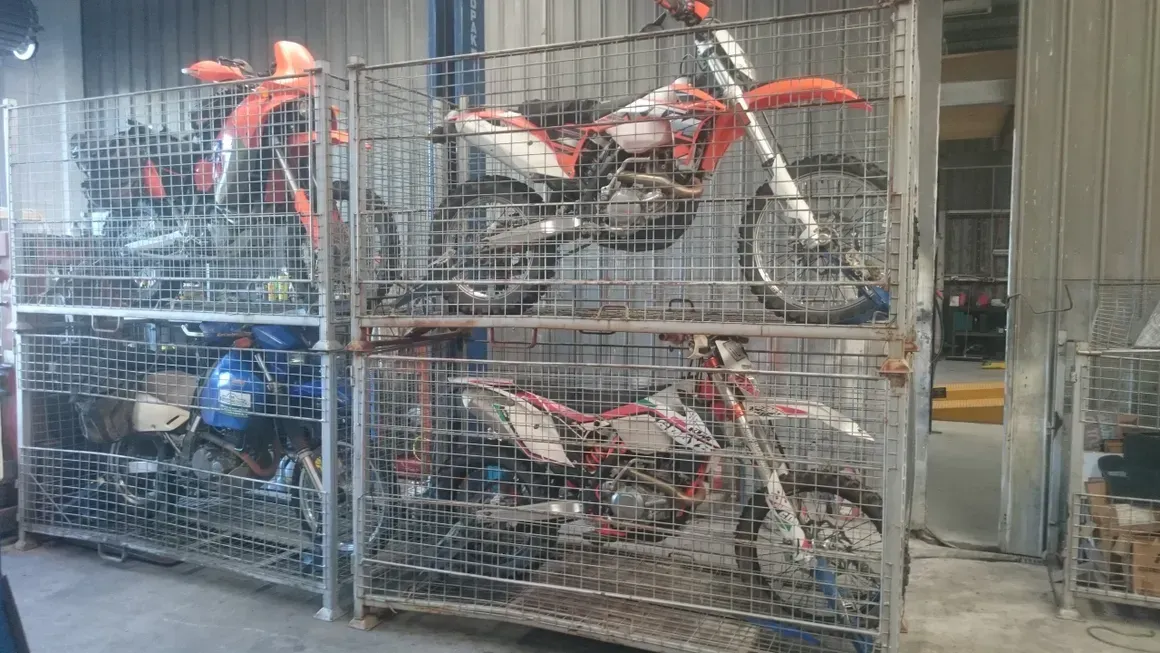 A Bunch Of Motorcycles Are Stacked On Top Of Each Other In A Cage — Motorcycle Transporters In Manunda, QLD
