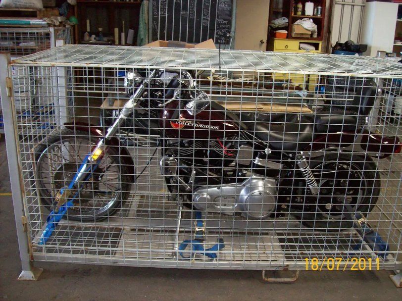 A Motorcycle Is Sitting In A Cage  — Motorcycle Transporters In Manunda, QLD