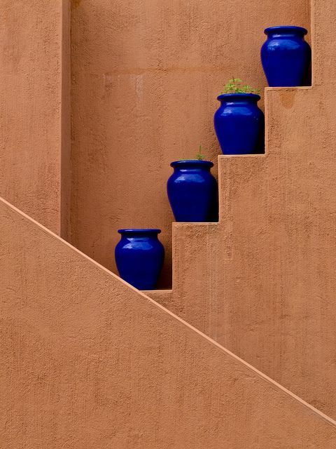 picture of brown plastered wall with blue bowls