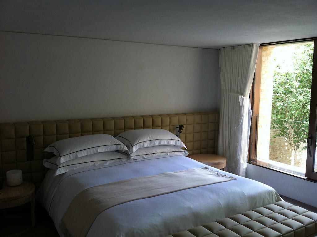 picture of a bedroom with a white bed and white suede wall and roof product