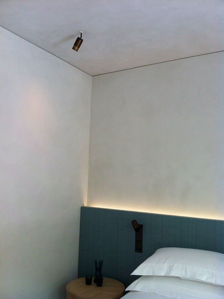 picture of a bedroom with green bed and white suede wall and roof product