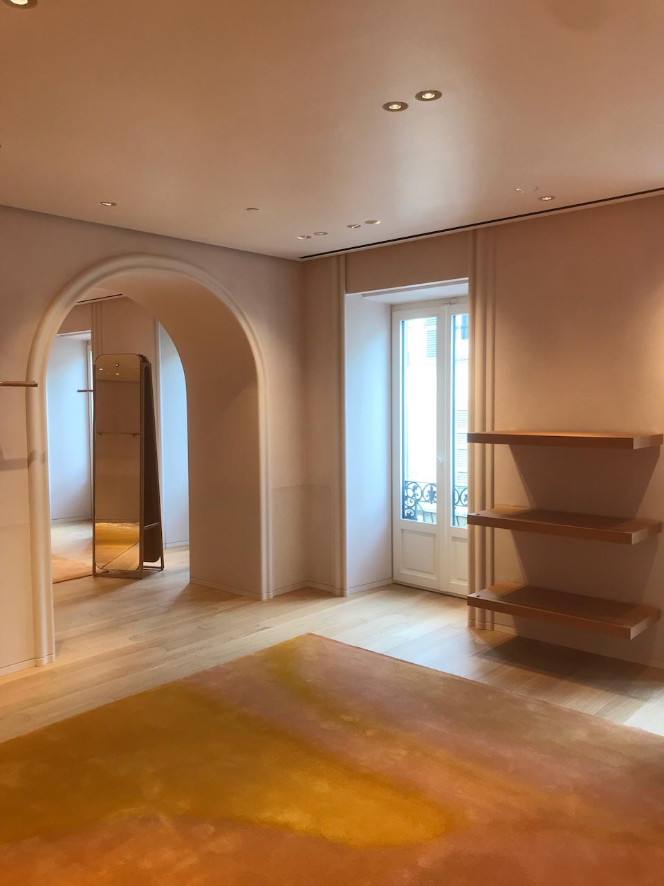 picture of a bright interior with arch and windows with sand suede walls and wooden floor