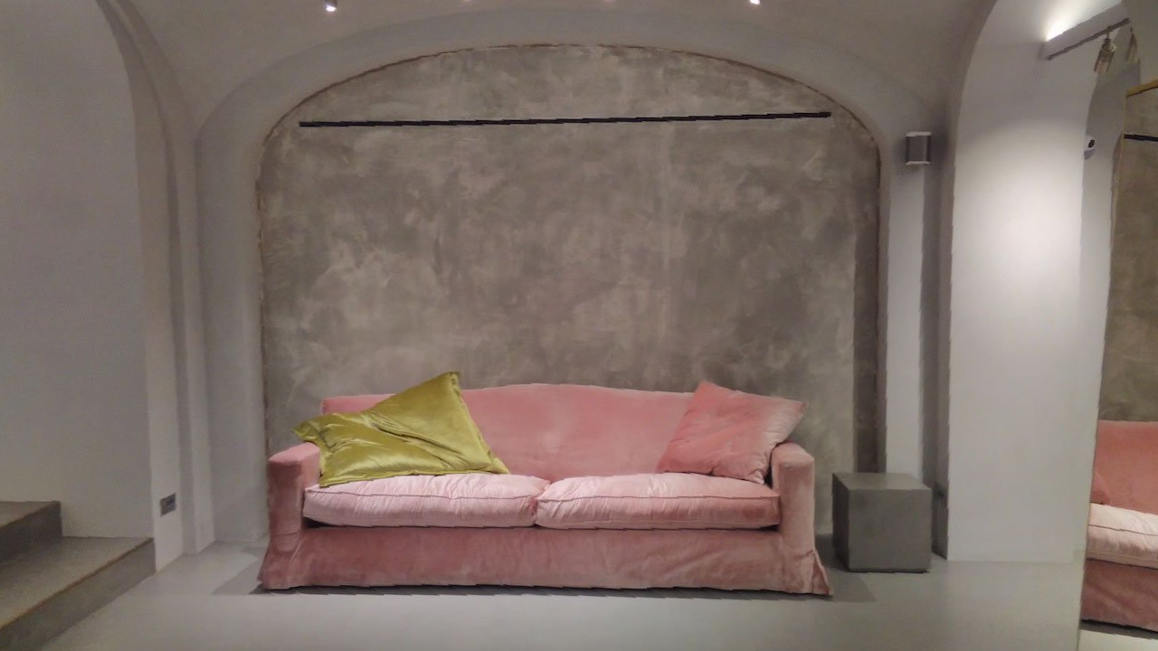 picture of a pink double sized sofa with a grey suede wall and roof product
