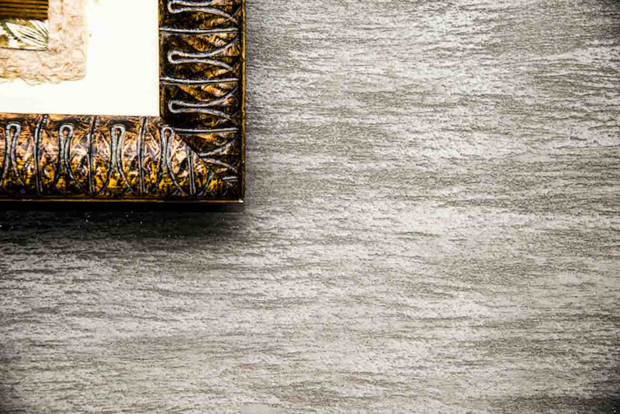 picture of a detail of grey plaster with a gold frame