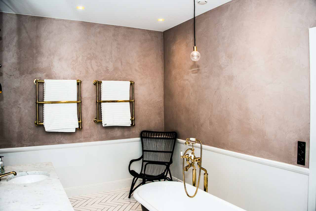 picture of bathroom with two towels and a bathub with pink tadelakt wall product