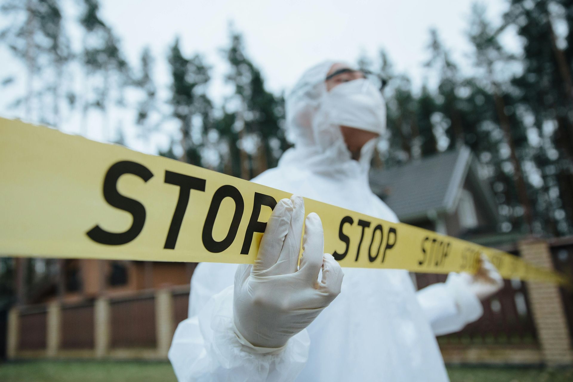 Person in hazmat suit holding yellow 