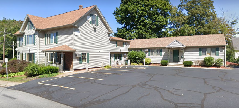 A little girl is sitting in a dental chair while a dentist examines her teeth.