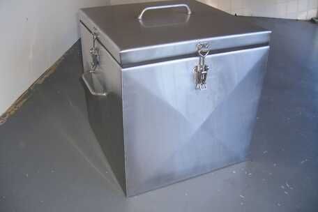 A stainless steel box with a handle is sitting on a concrete floor.