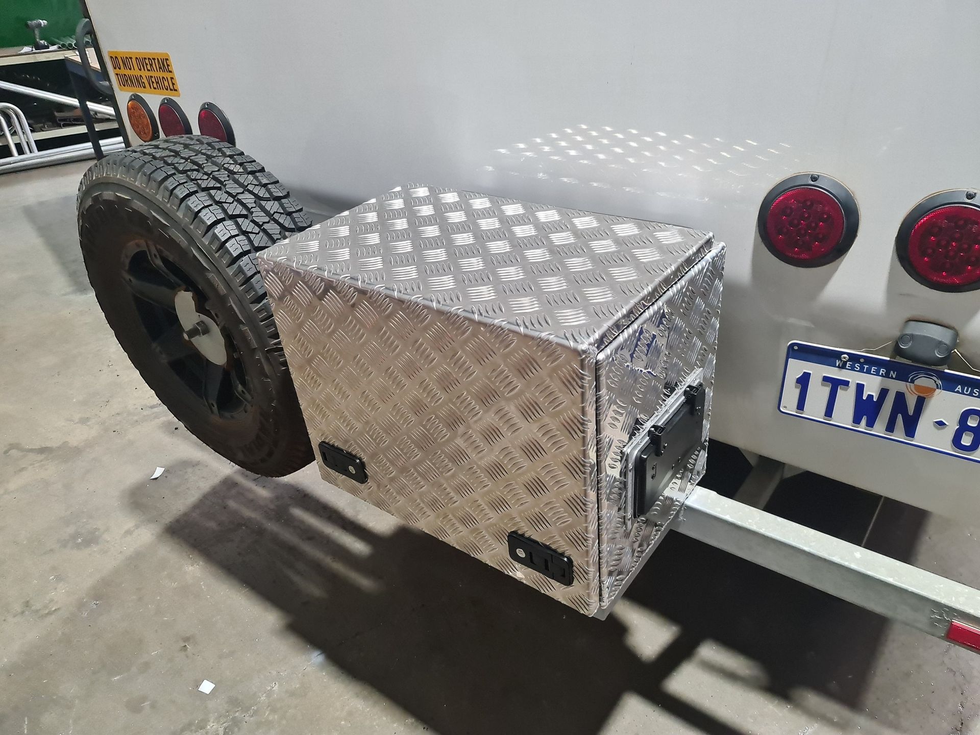 A silver box is attached to the back of a trailer.