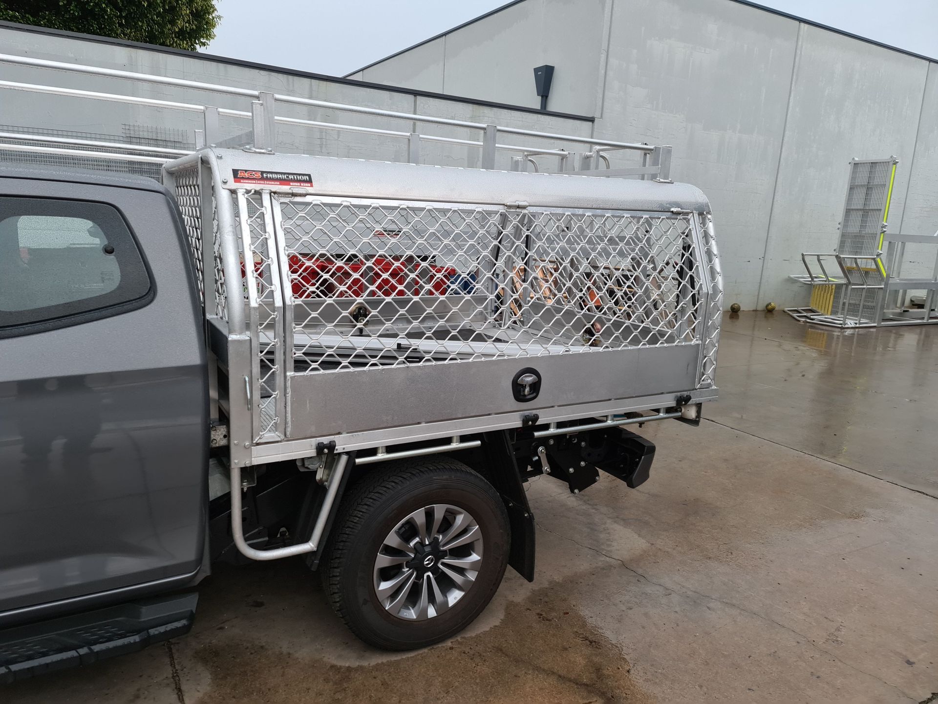 A truck with a cage on the back of it is parked in a parking lot.