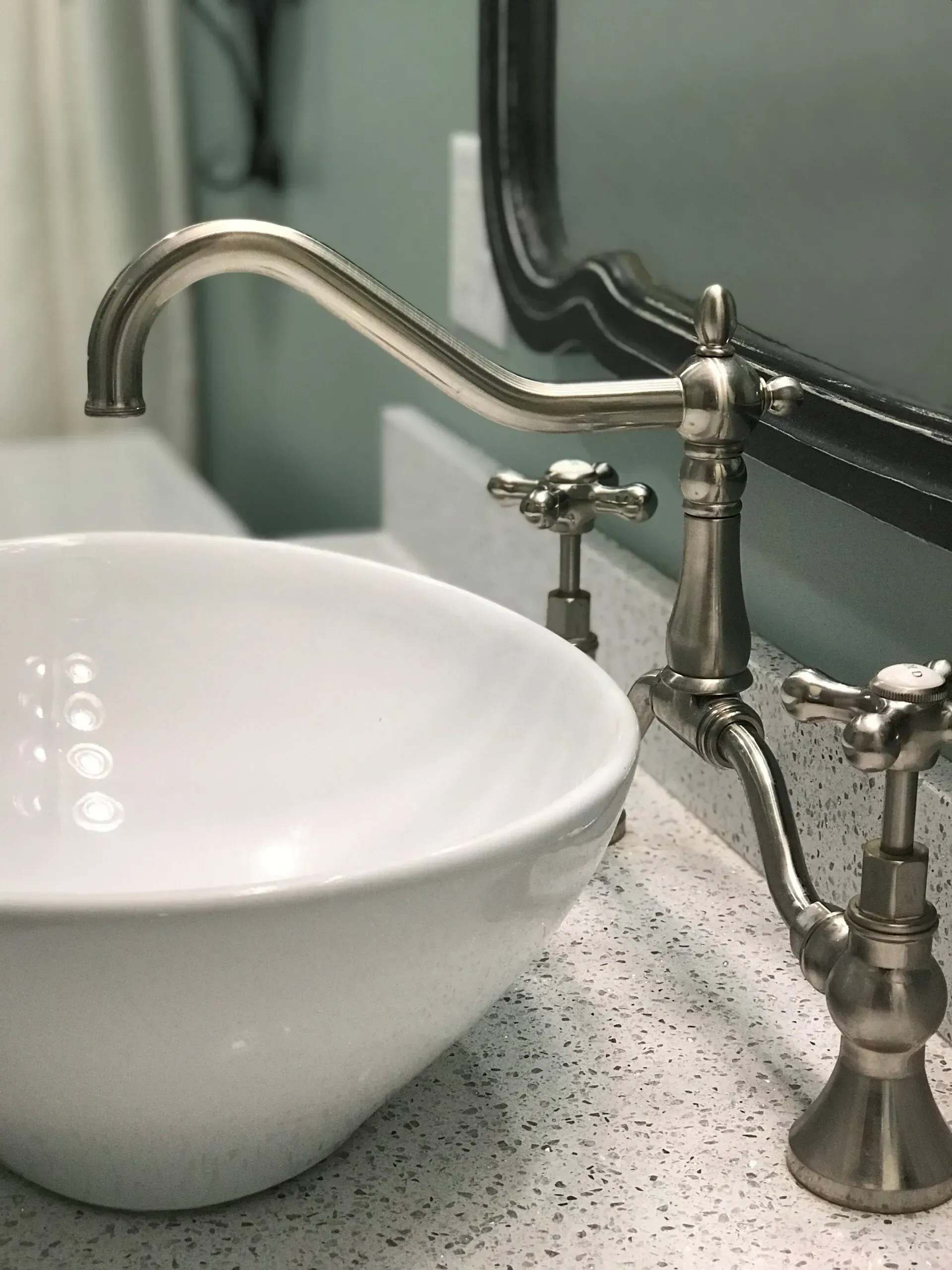 A bathroom sink with a faucet and a mirror