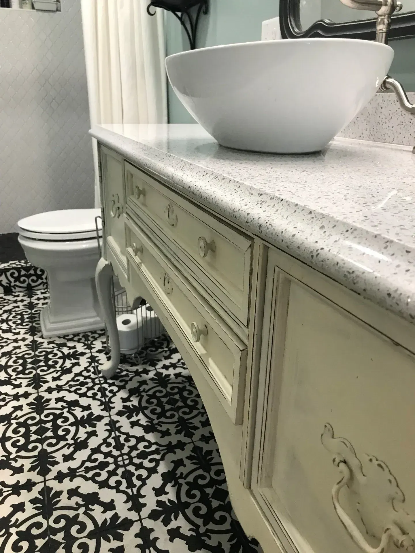 A bathroom with a sink , toilet , and dresser.