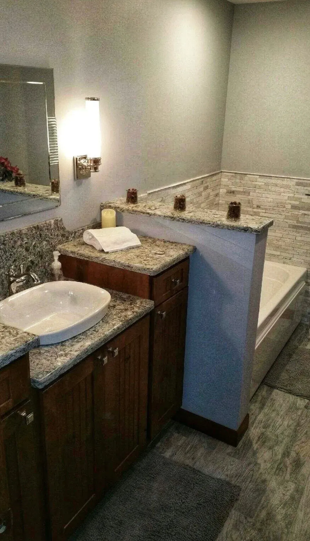 A bathroom with a sink , mirror and tub.