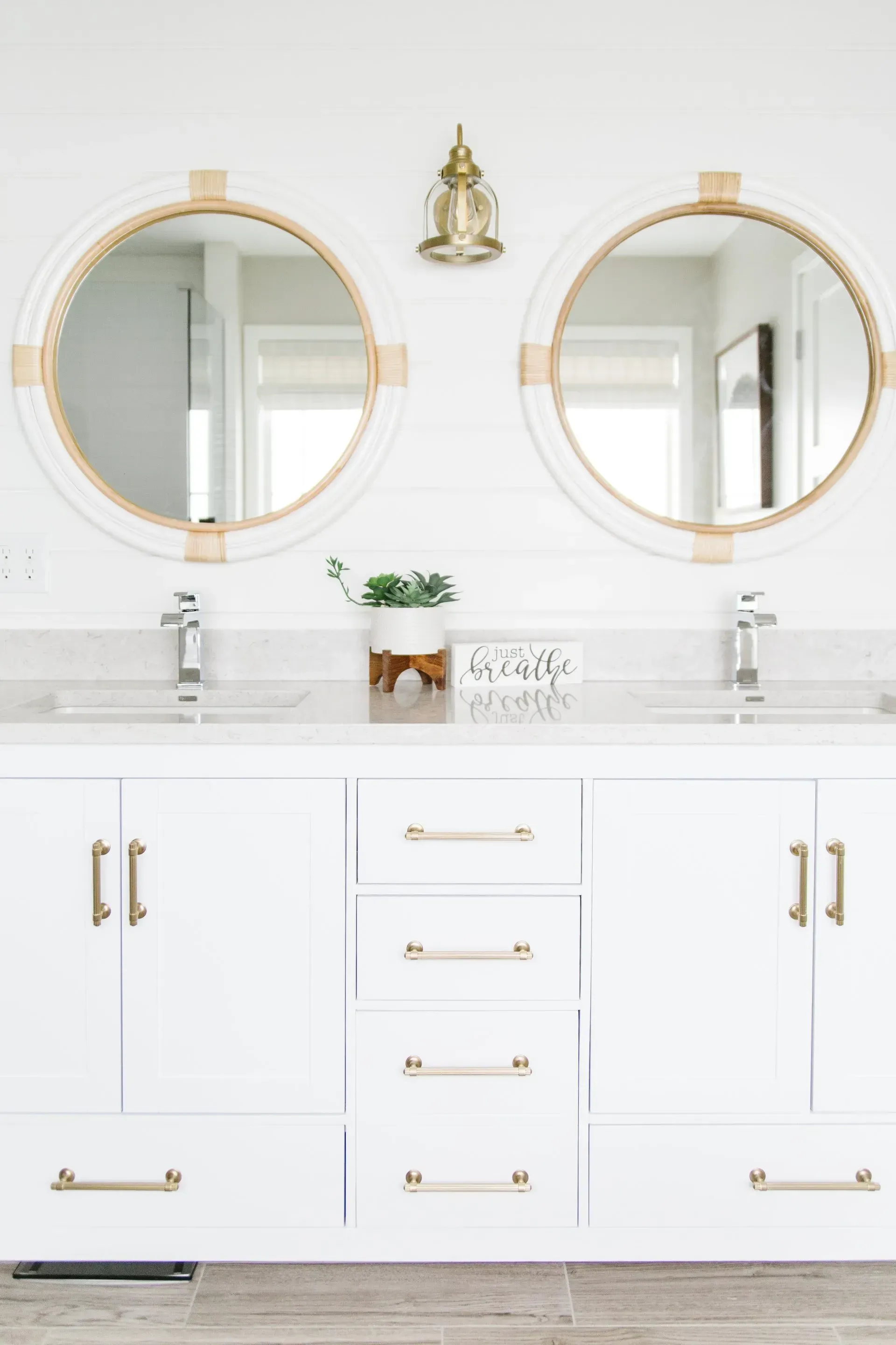 A bathroom with two sinks and two round mirrors.