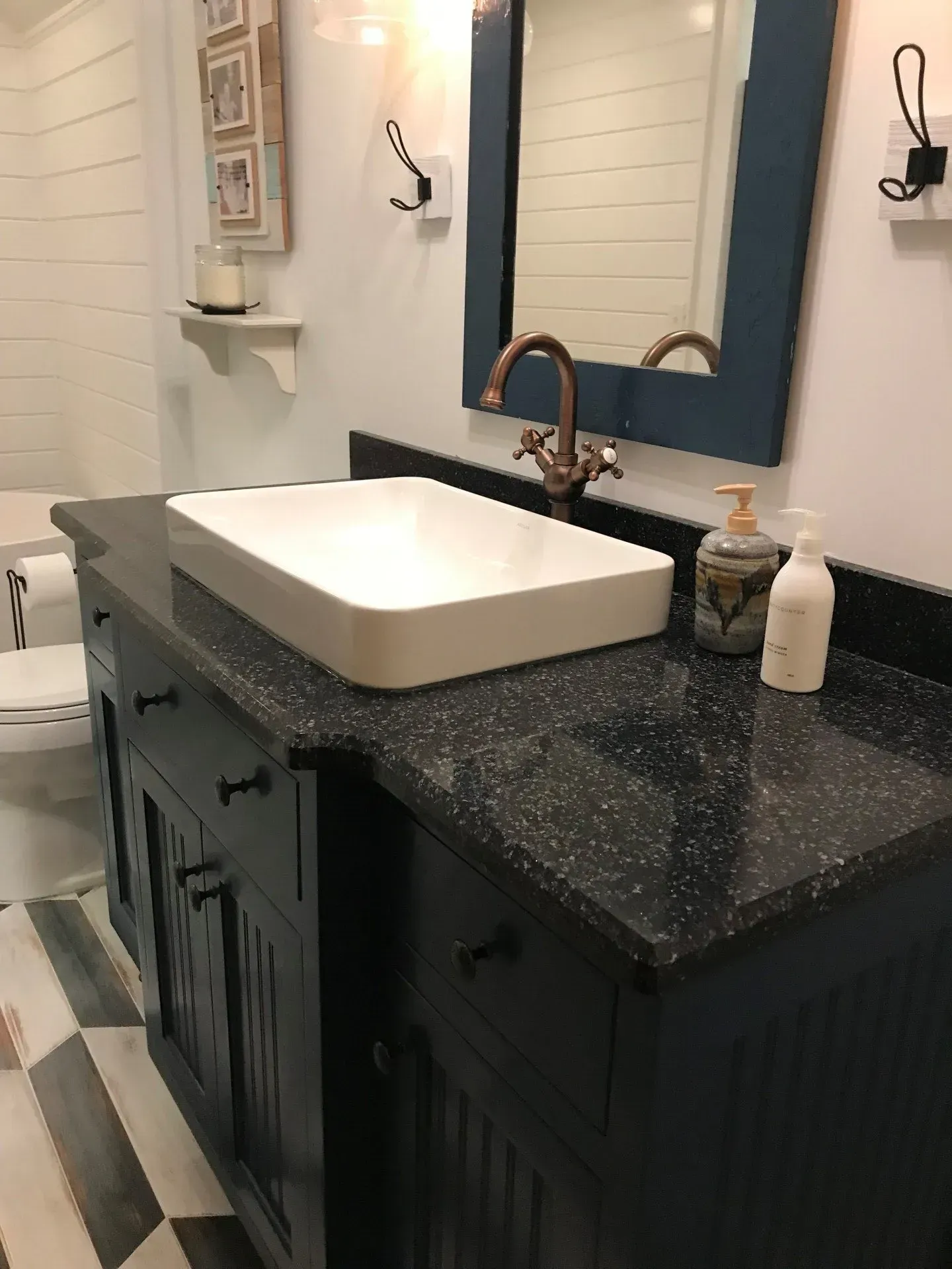 A bathroom with a sink , mirror and toilet.
