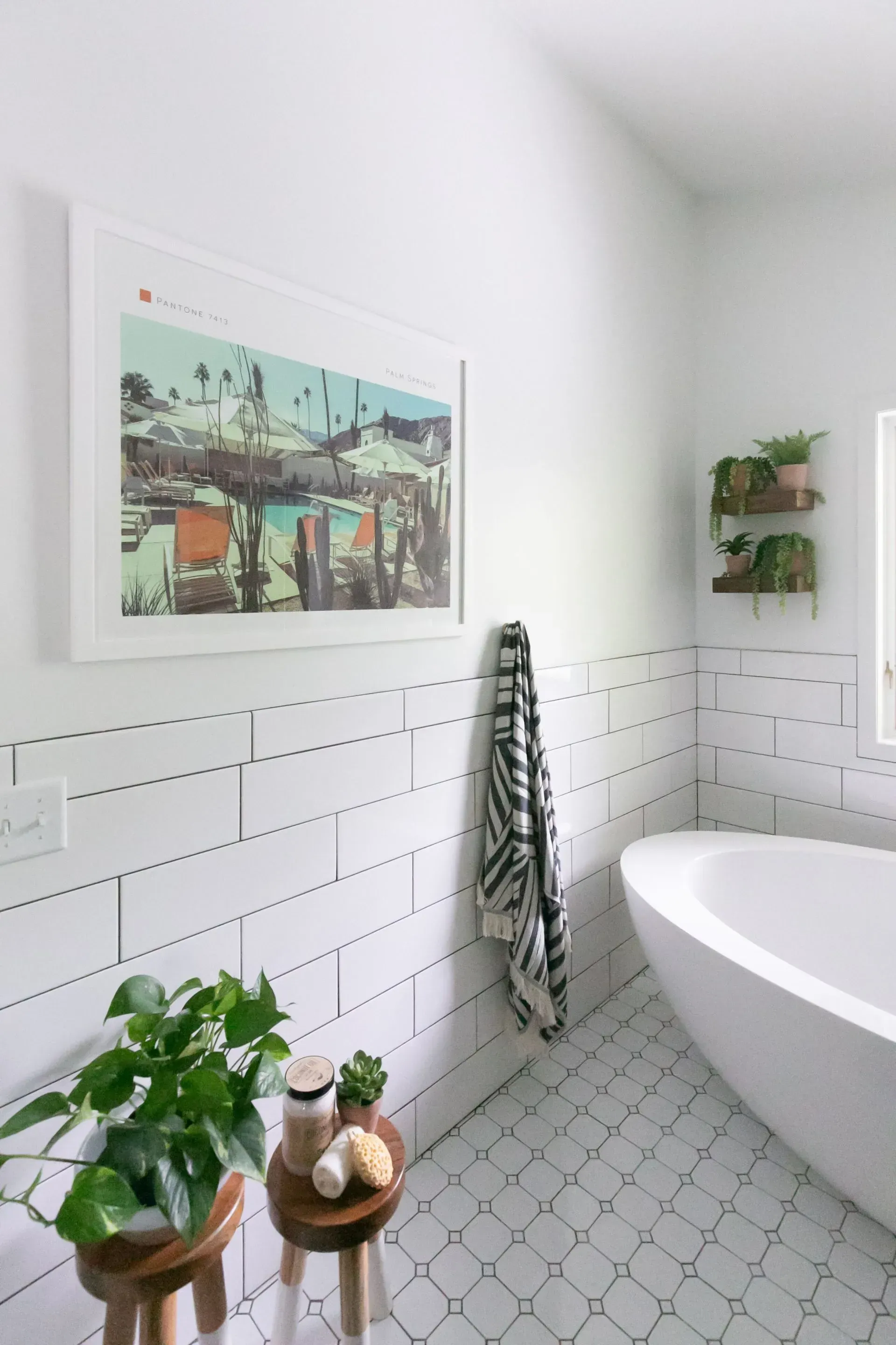 A bathroom with a bathtub and a picture on the wall above it.