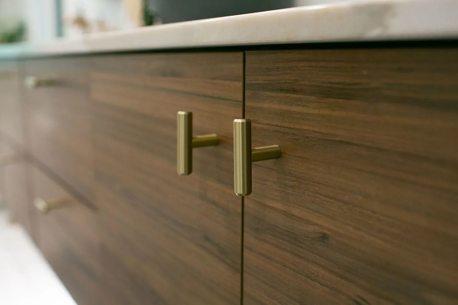 A close up of a wooden cabinet with brass handles.