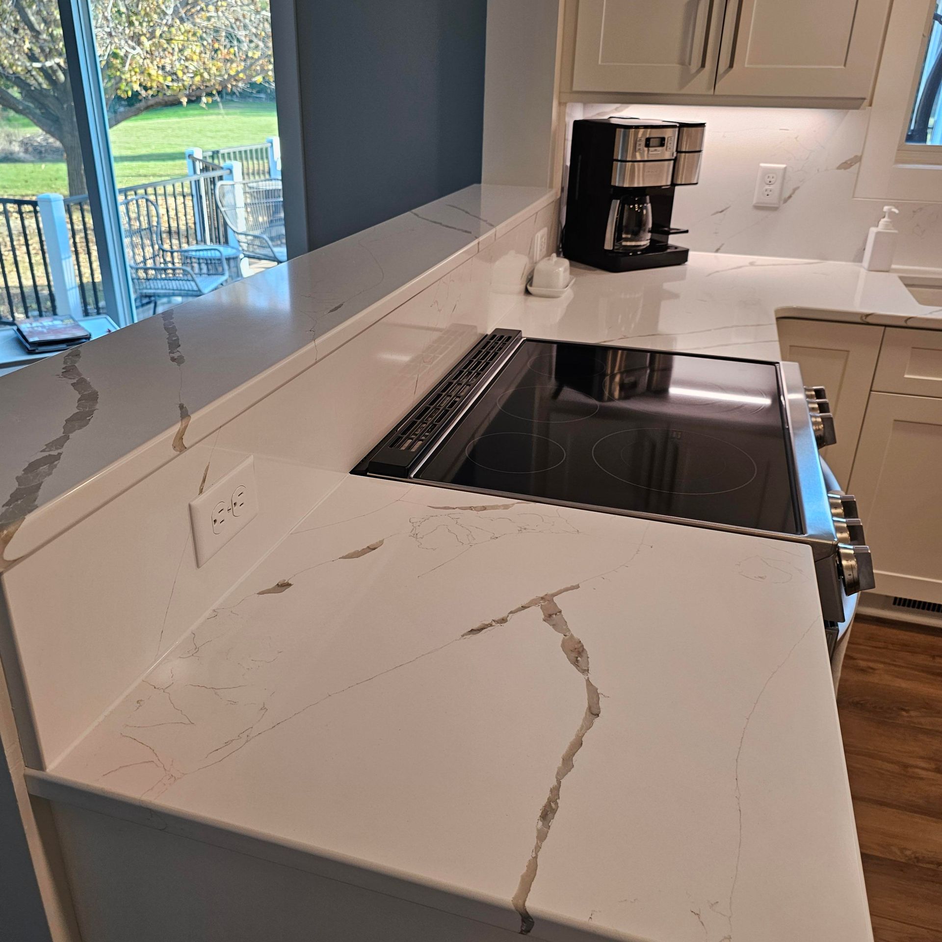 A kitchen with a stove and a coffee maker on the counter.
