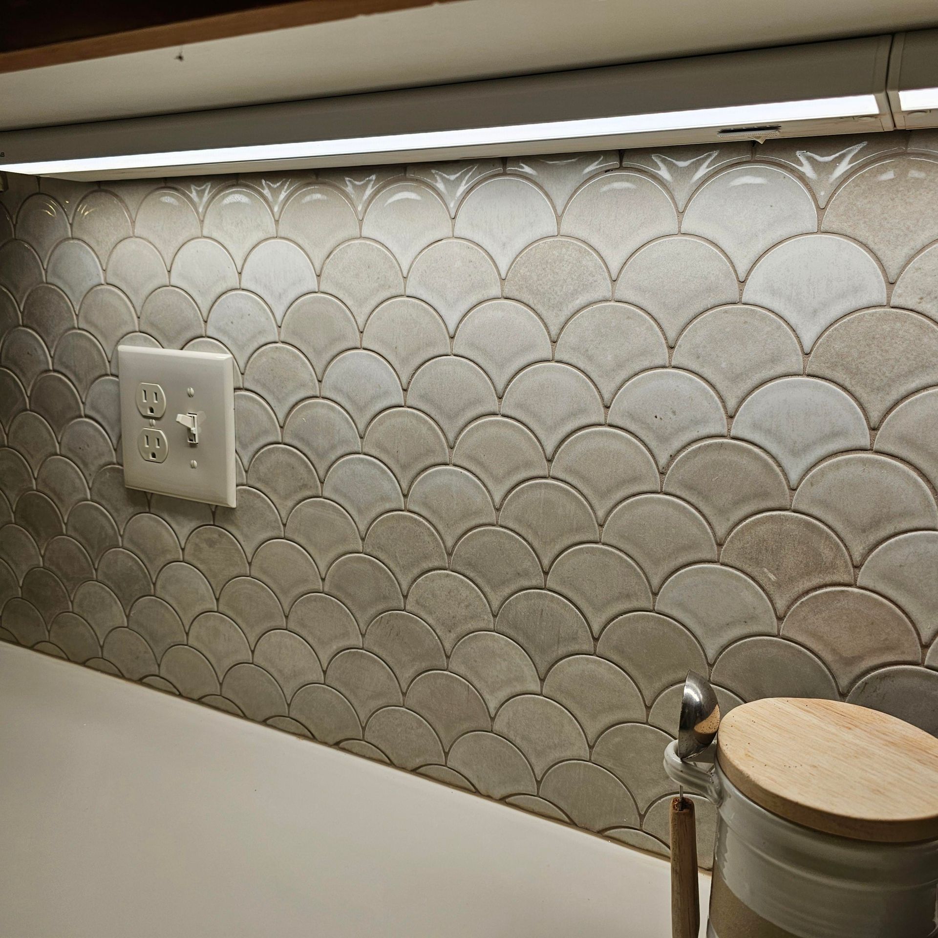 A kitchen with a fish scale pattern on the wall