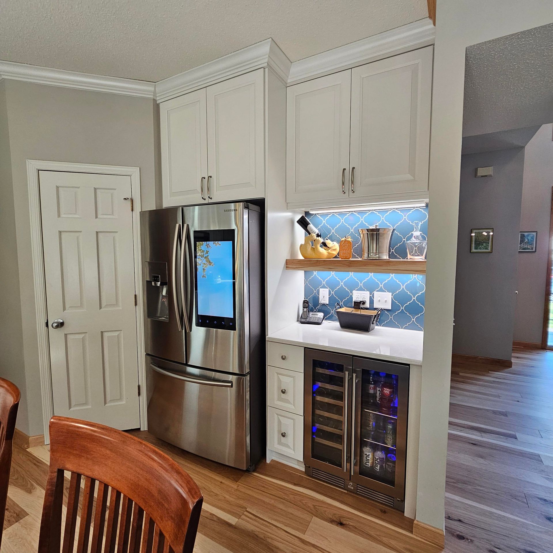 A kitchen with a stainless steel refrigerator and a wine cooler