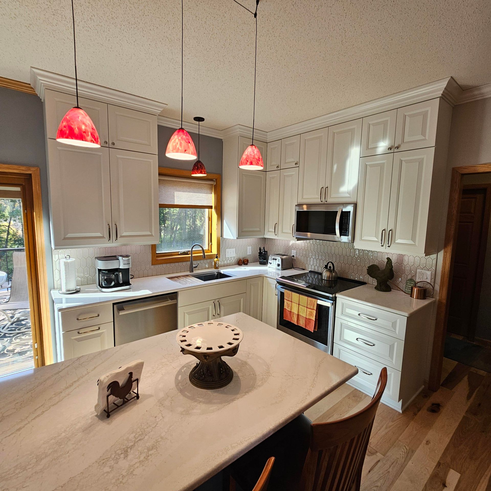 A kitchen with white cabinets and a table with a cake on it