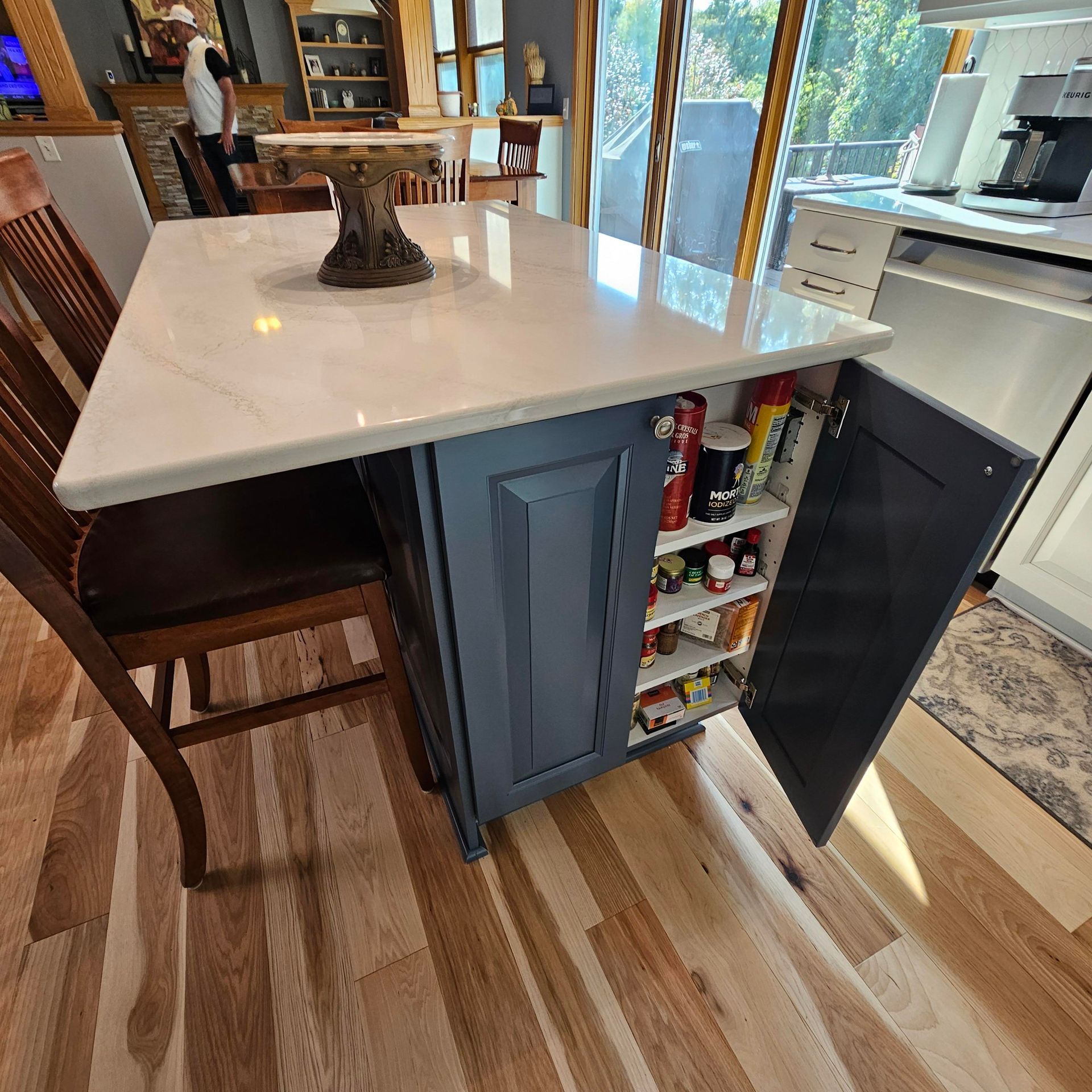 A kitchen with a table and chairs and a pantry with the door open
