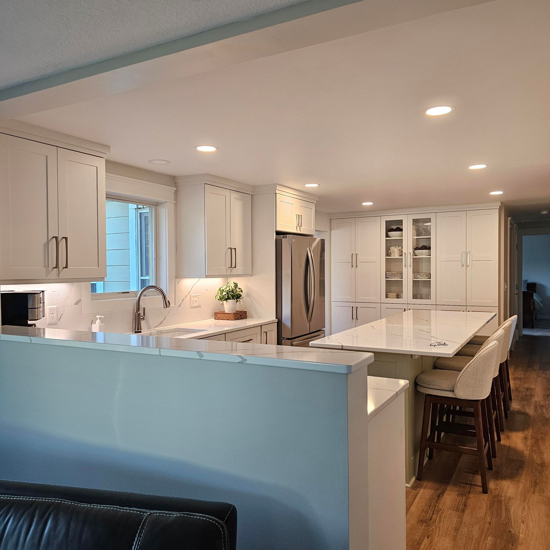 A kitchen with white cabinets and a large island in the middle
