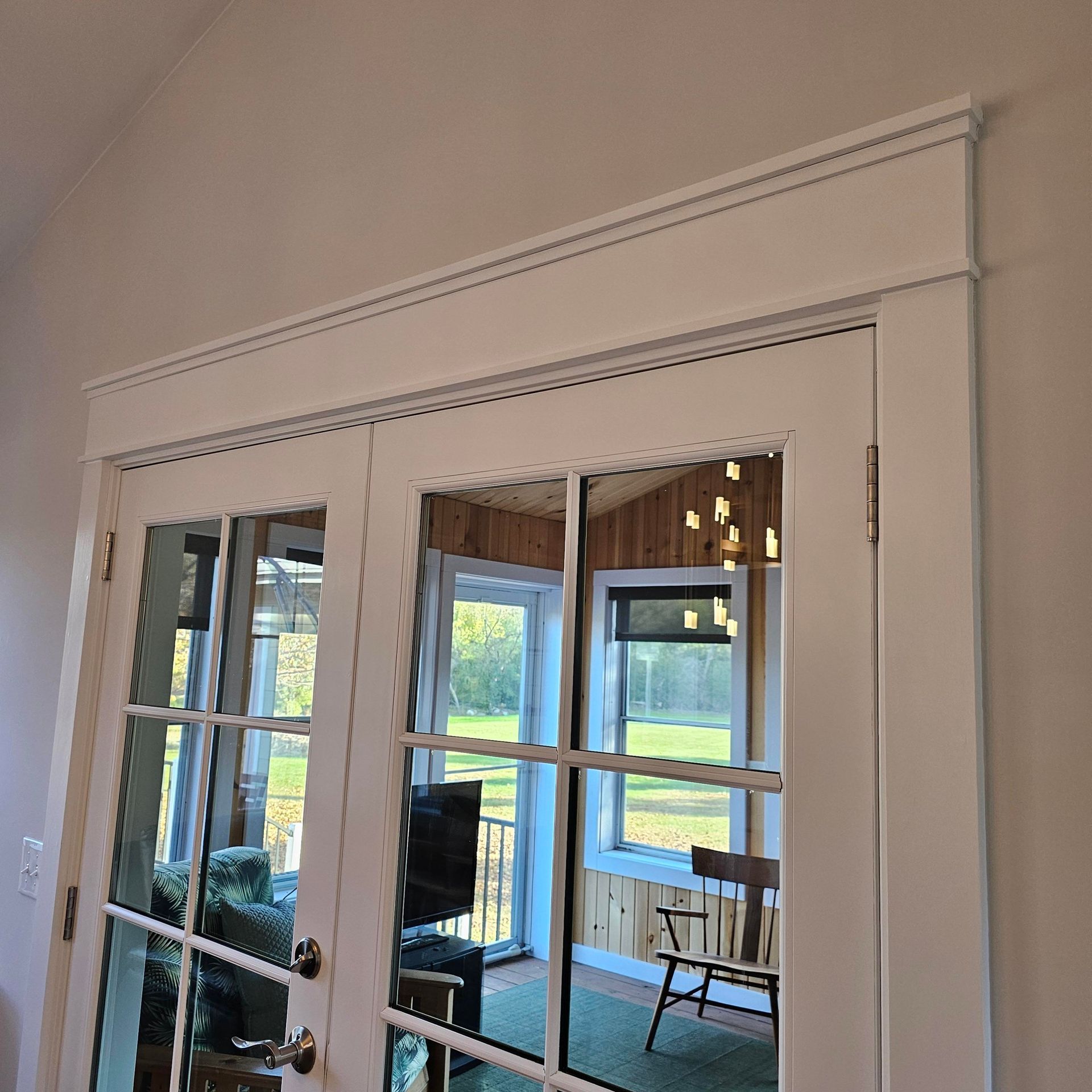 A french door with a reflection of a living room in it.