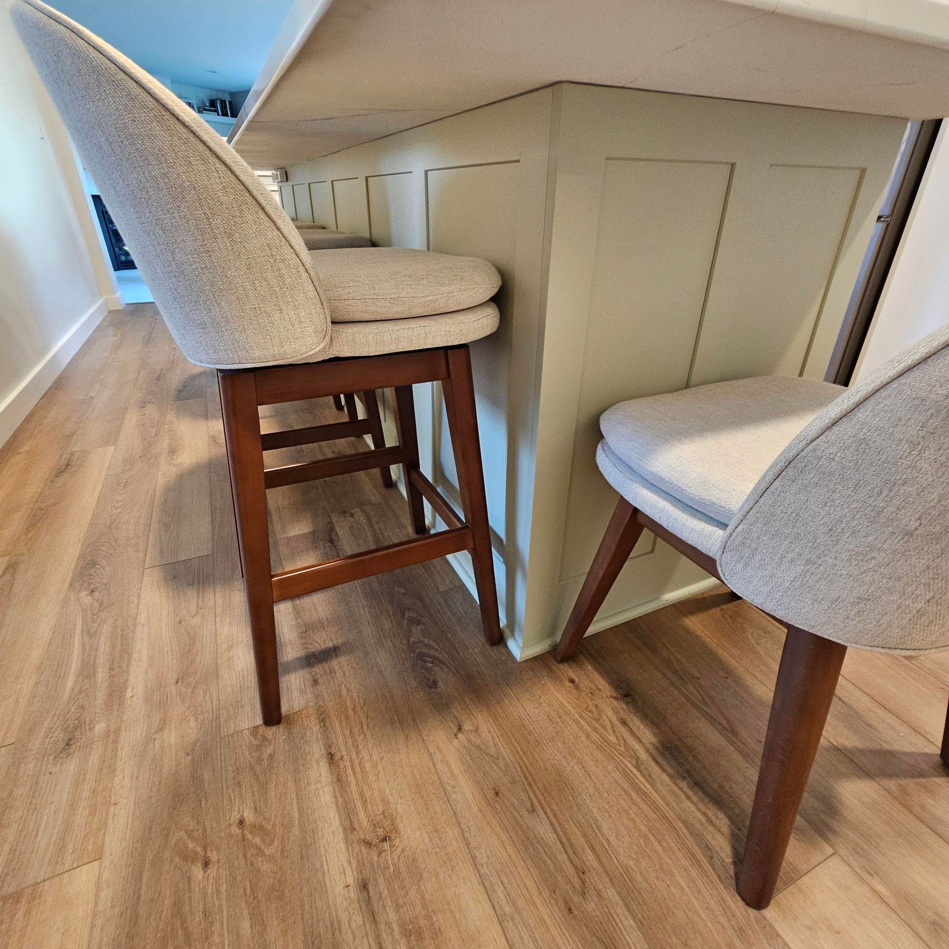 Two bar stools are sitting next to a counter in a kitchen.