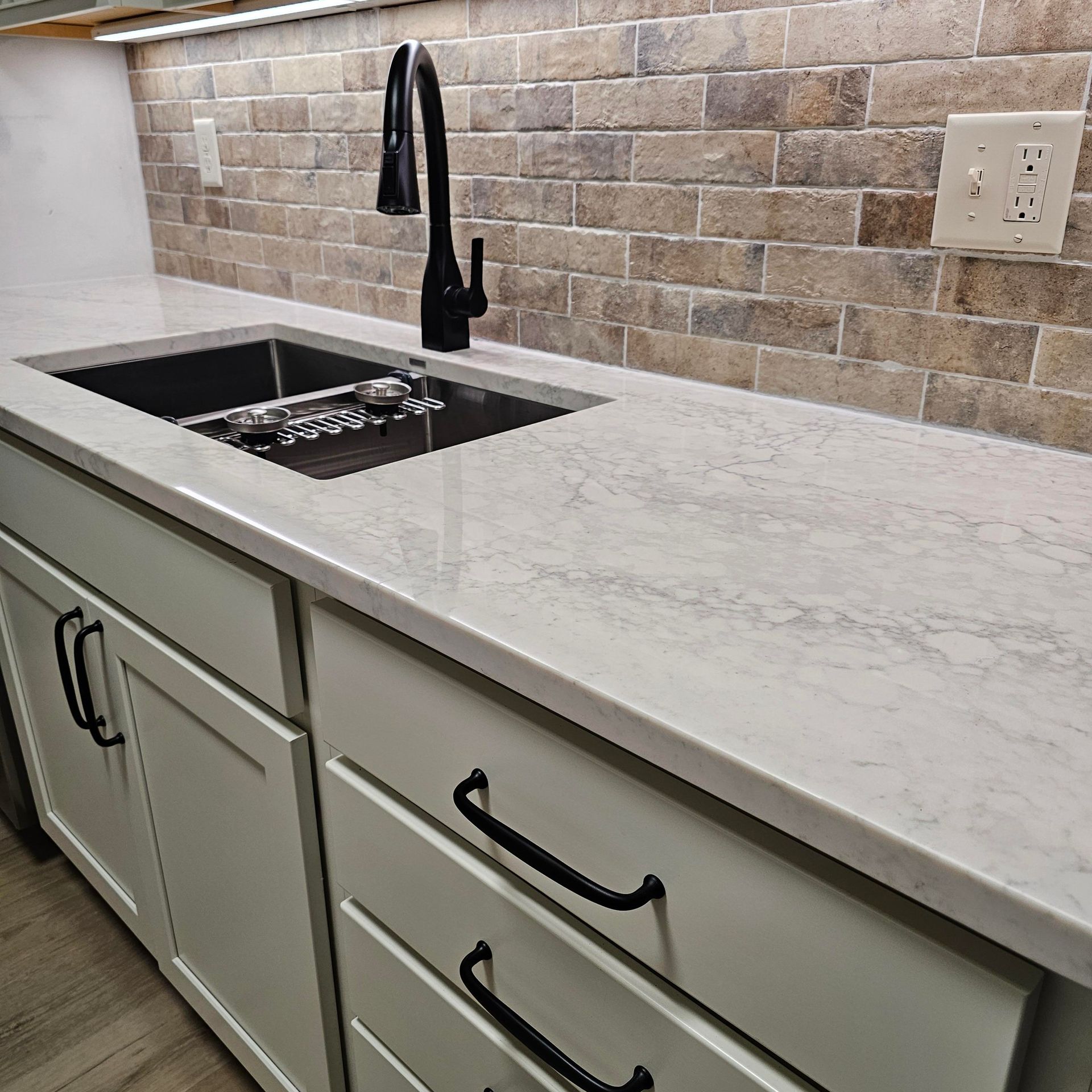 A kitchen counter with a sink and a faucet