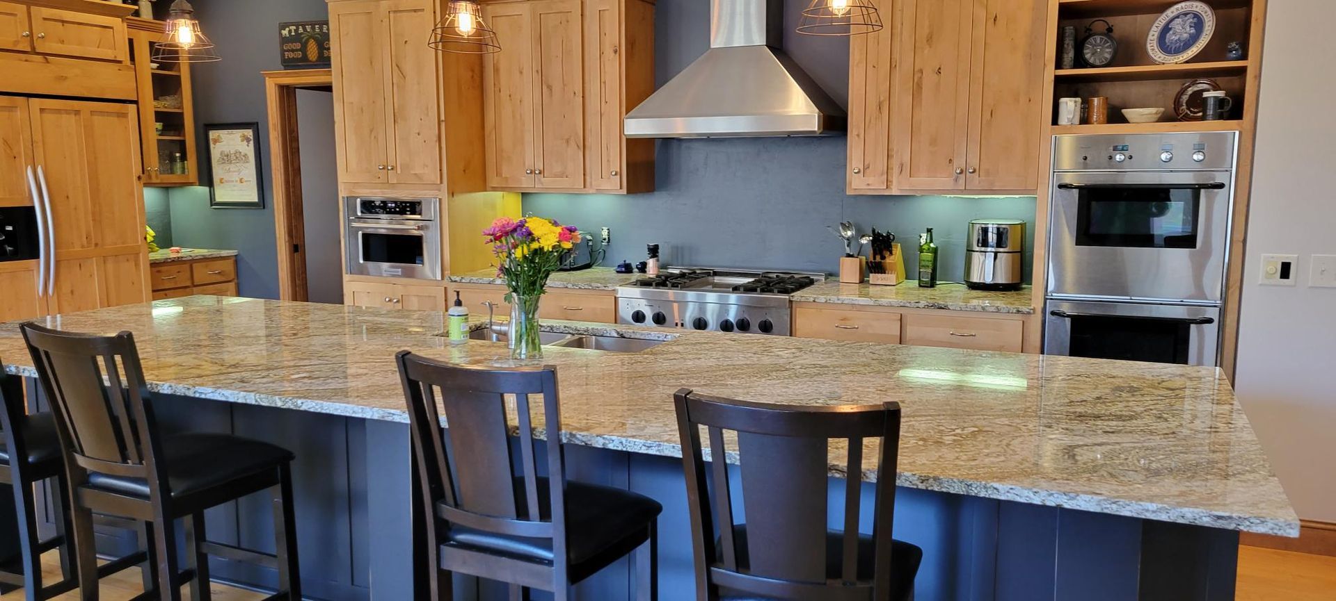 A kitchen with granite counter tops , stainless steel appliances , and wooden cabinets.
