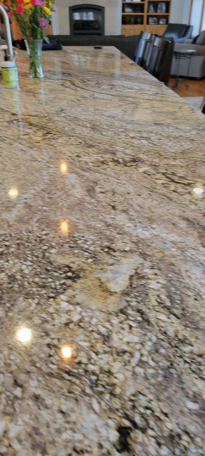 A kitchen counter with a vase of flowers on it.