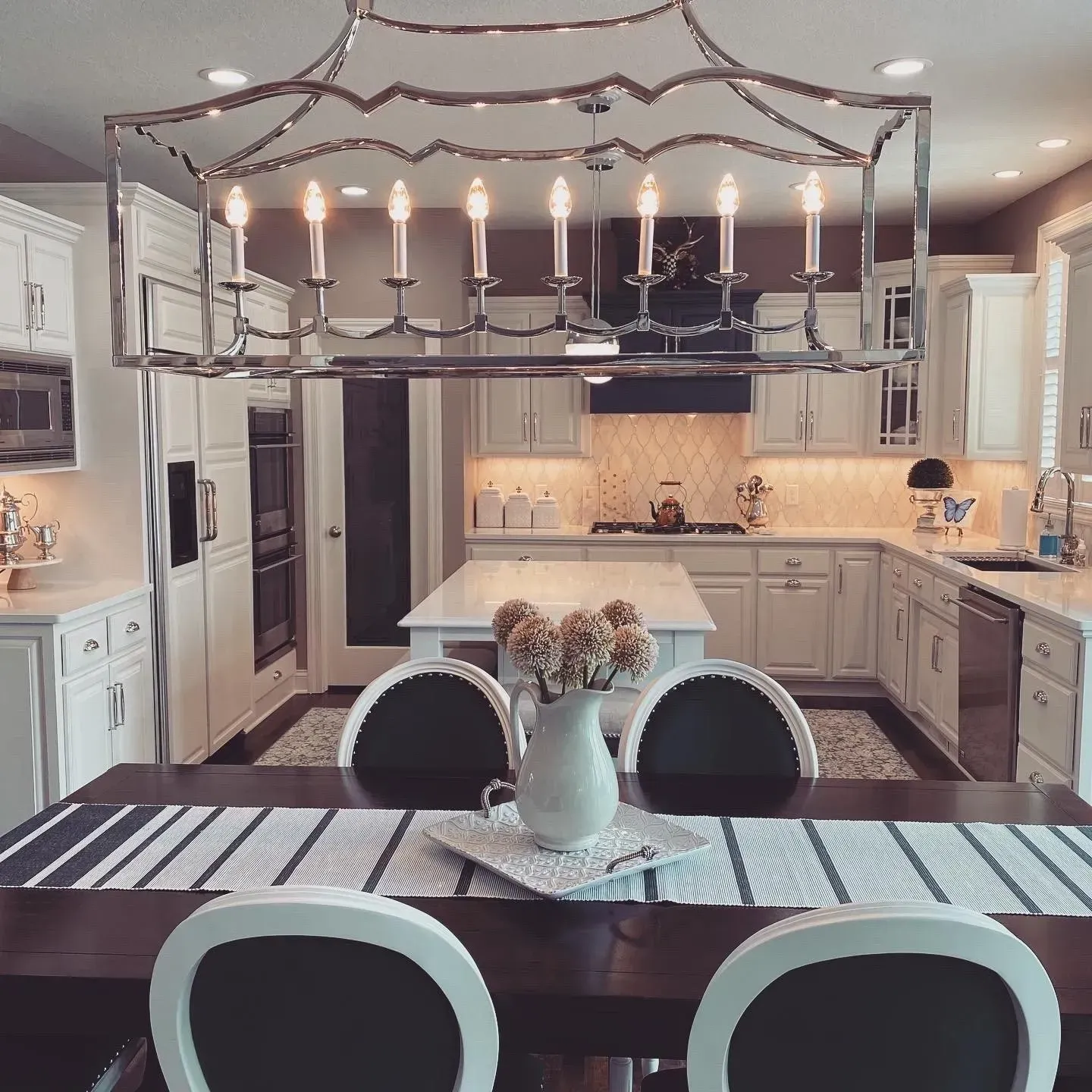 A kitchen with a table and chairs and a chandelier