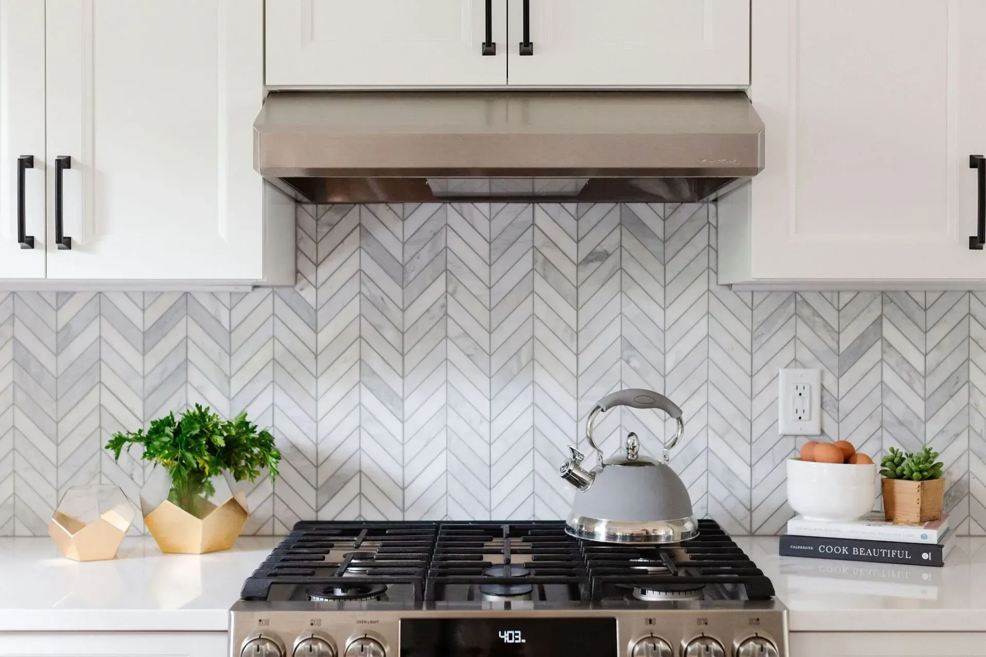 A kitchen with a stove and a kettle on it.