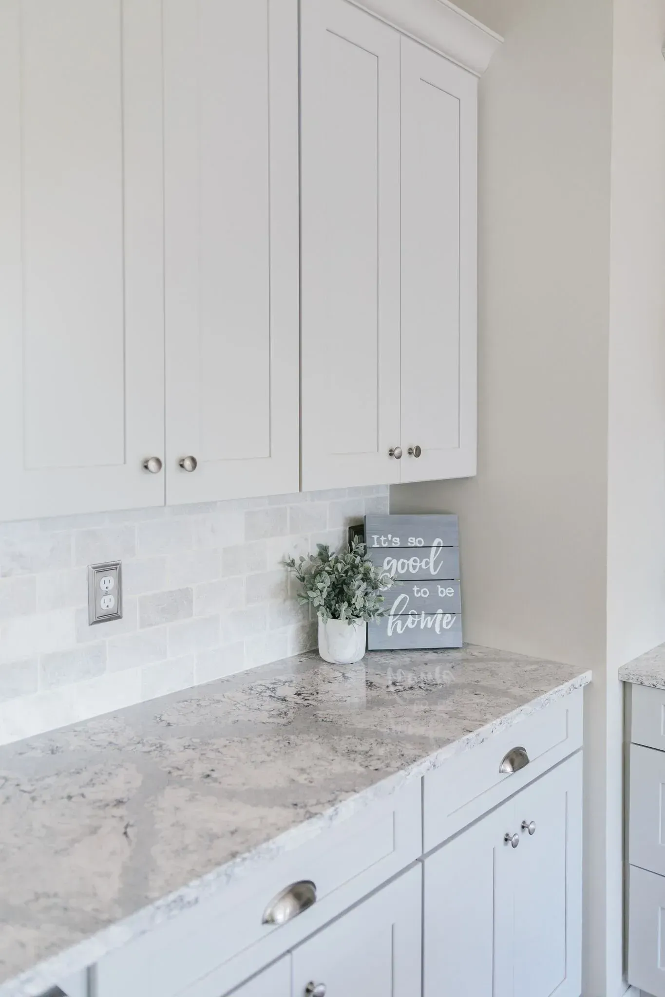 A kitchen with white cabinets and granite counter tops.