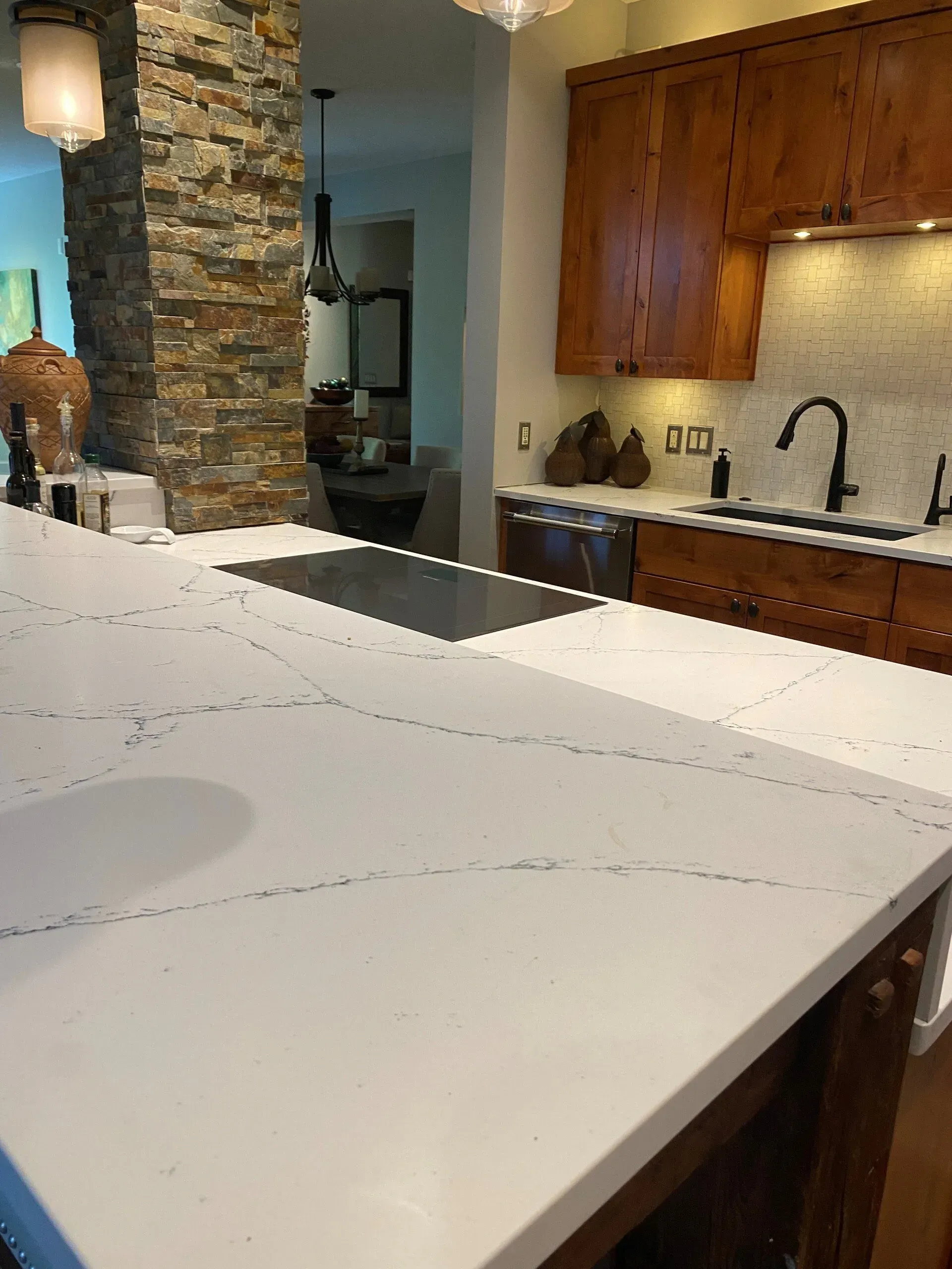 A kitchen with a large white counter top and wooden cabinets.