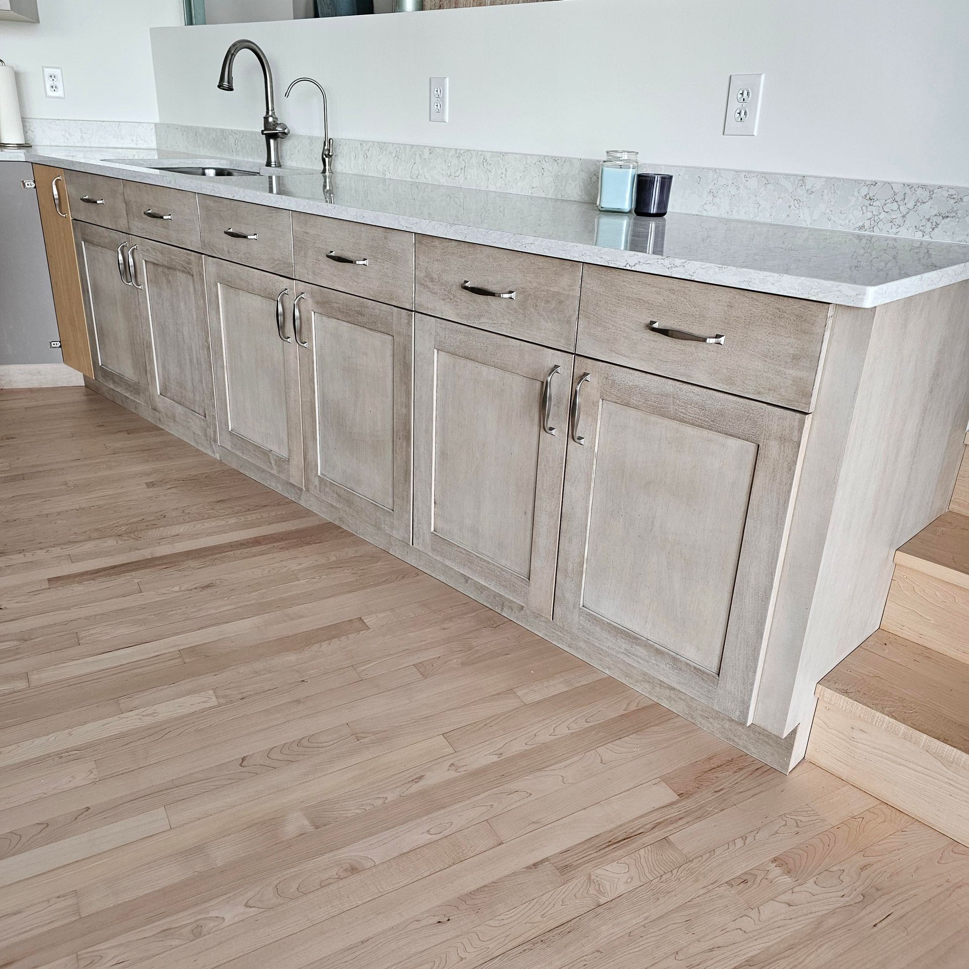 A kitchen with wooden cabinets and marble counter tops