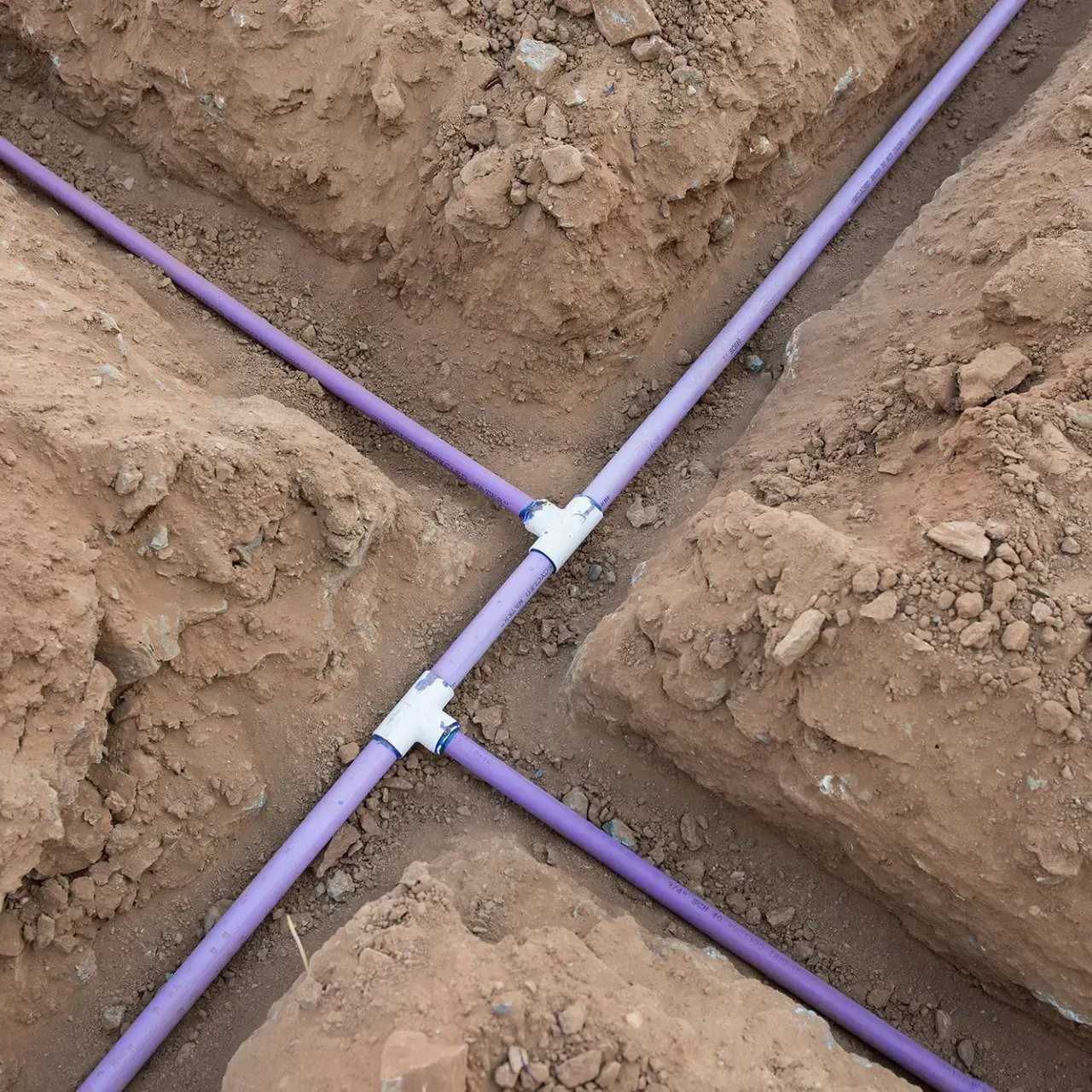 Purple pipes are connected to each other in the dirt