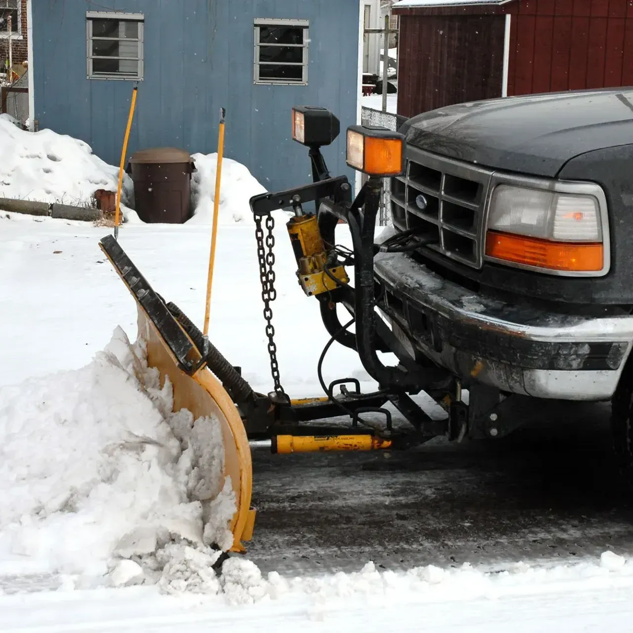 A snow plow is attached to the front of a truck