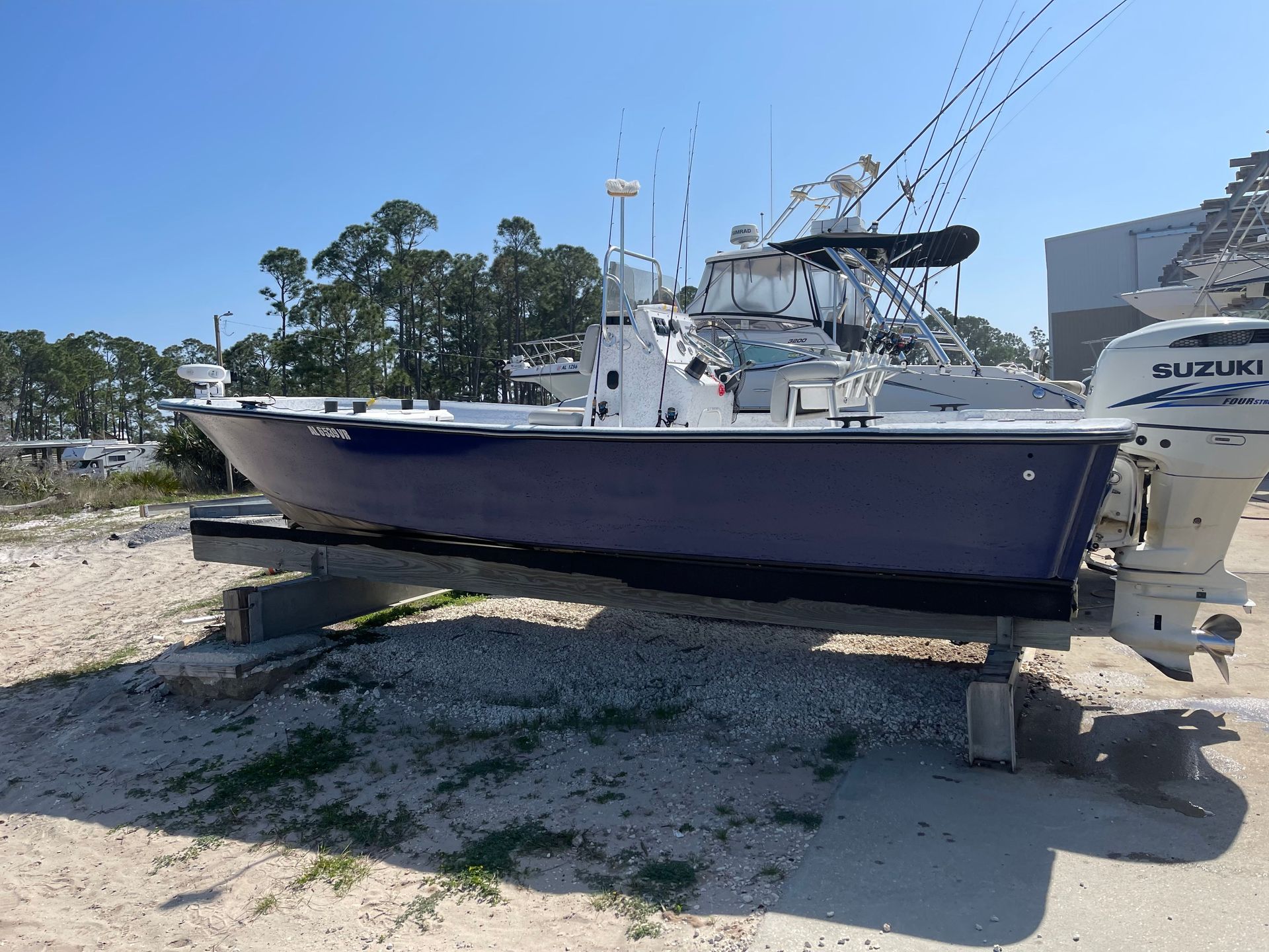 A purple and white boat with a suzuki outboard motor