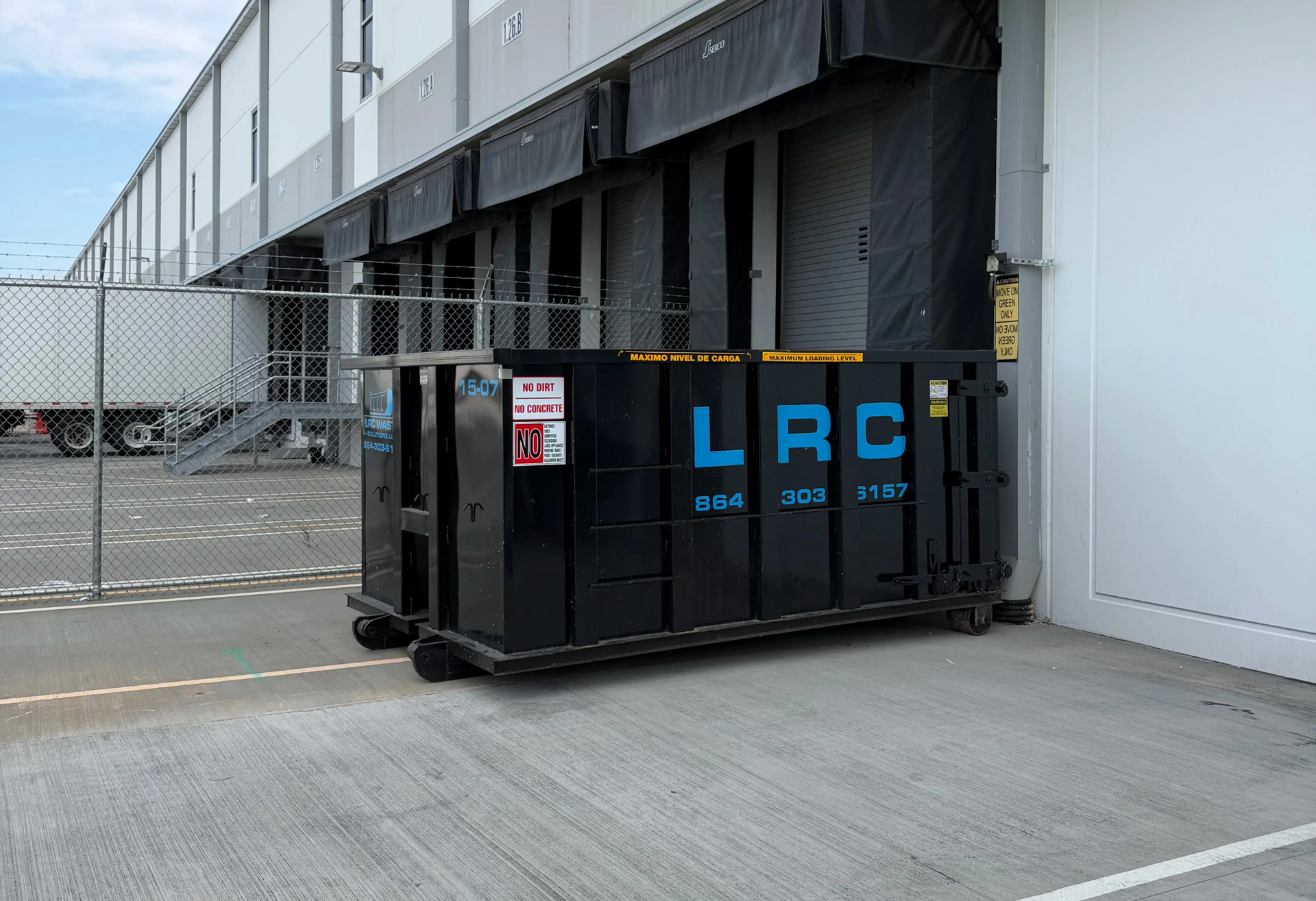 Black dumpster labeled 