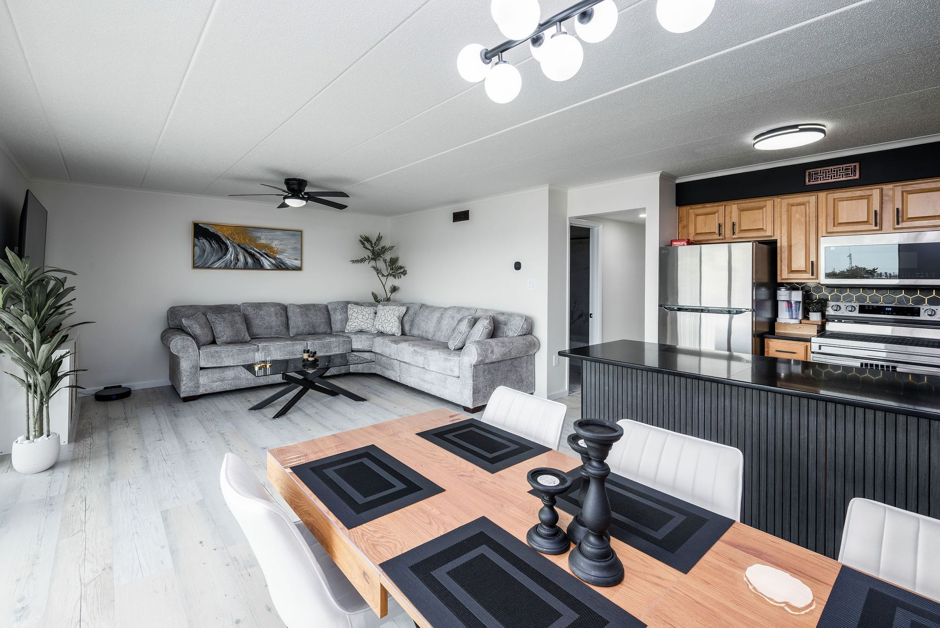 Modern living room with sectional sofa, dining table, and open kitchen.