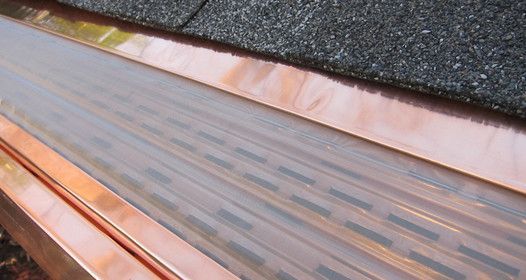 a close up of a copper gutter on a roof .