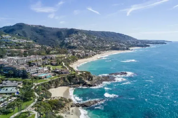 an aerial view of a beach surrounded by mountains and a body of water .