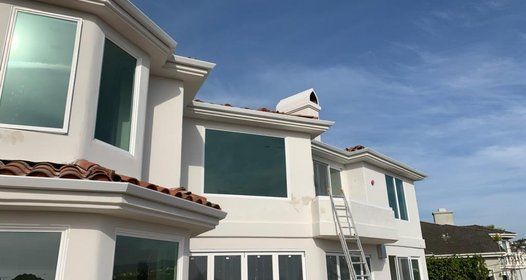 a large white house with a ladder on the side of it .