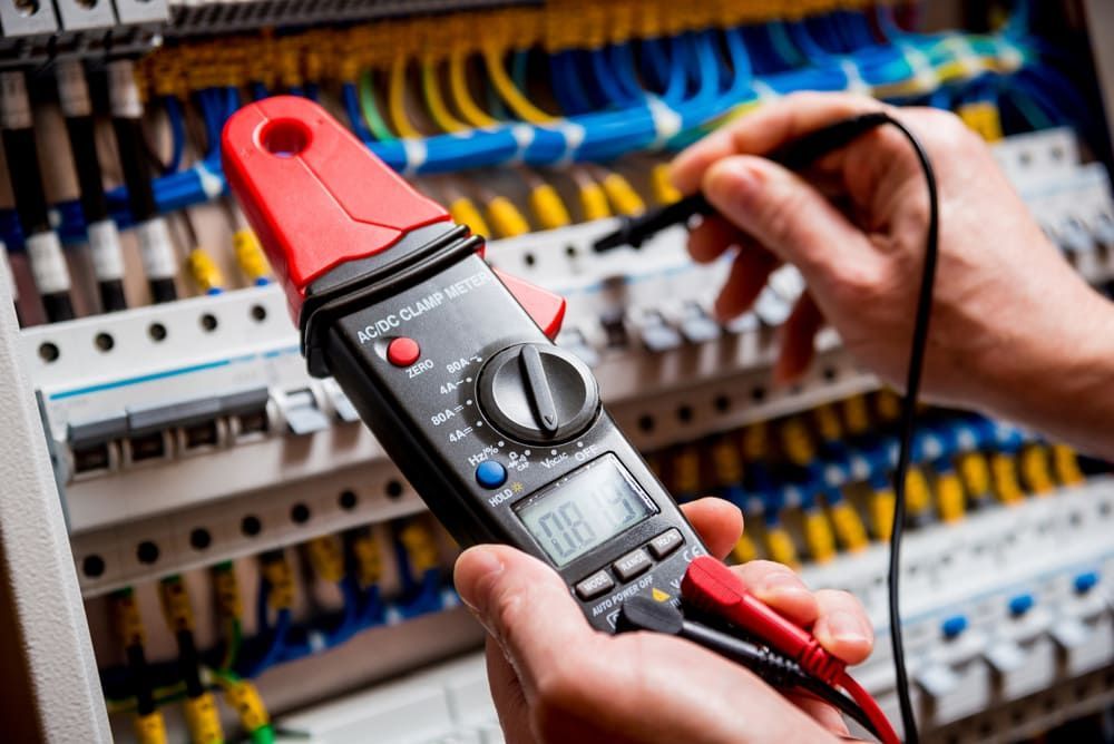 A Person Is Using A Clamp Meter To Test A Circuit Board — Mackies In Port Macquarie, NSW