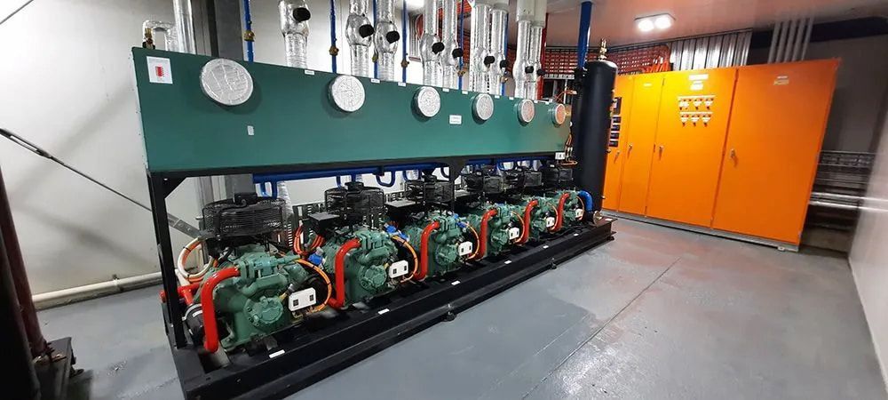 A Large Machine Is Sitting In A Room Next To A Row Of Orange Cabinets — Mackies In Taree, NSW